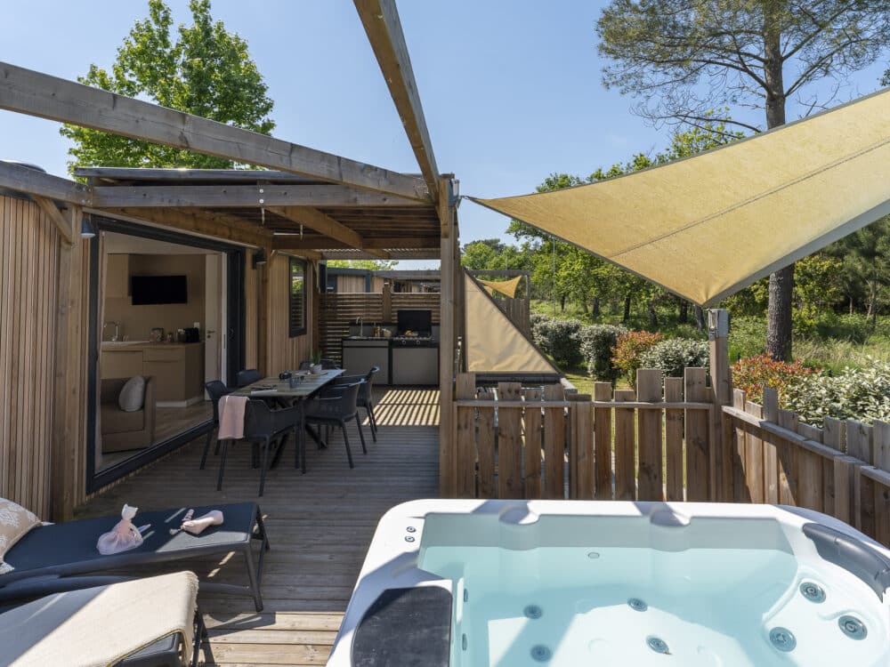 Holzterrasse mit Whirlpool und Sitzgelegenheiten im Freien.