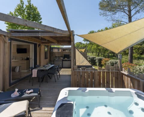 Terrasse en bois avec jacuzzi et salon extérieur.