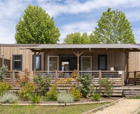 Chalet en bois avec terrasse fleurie.